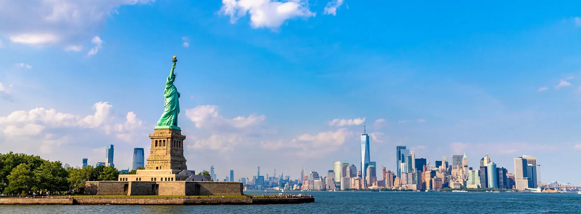 Statue of Liberty with New York City skyline on a bright summer day