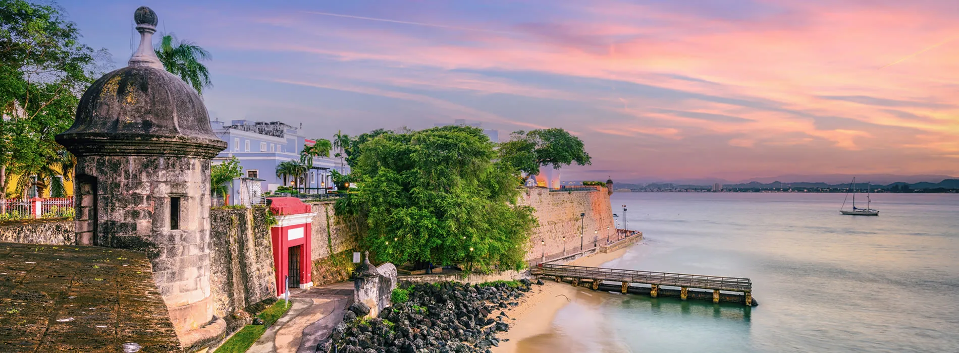 Historic Old San Juan fortification wall with colorful sunset over harbor