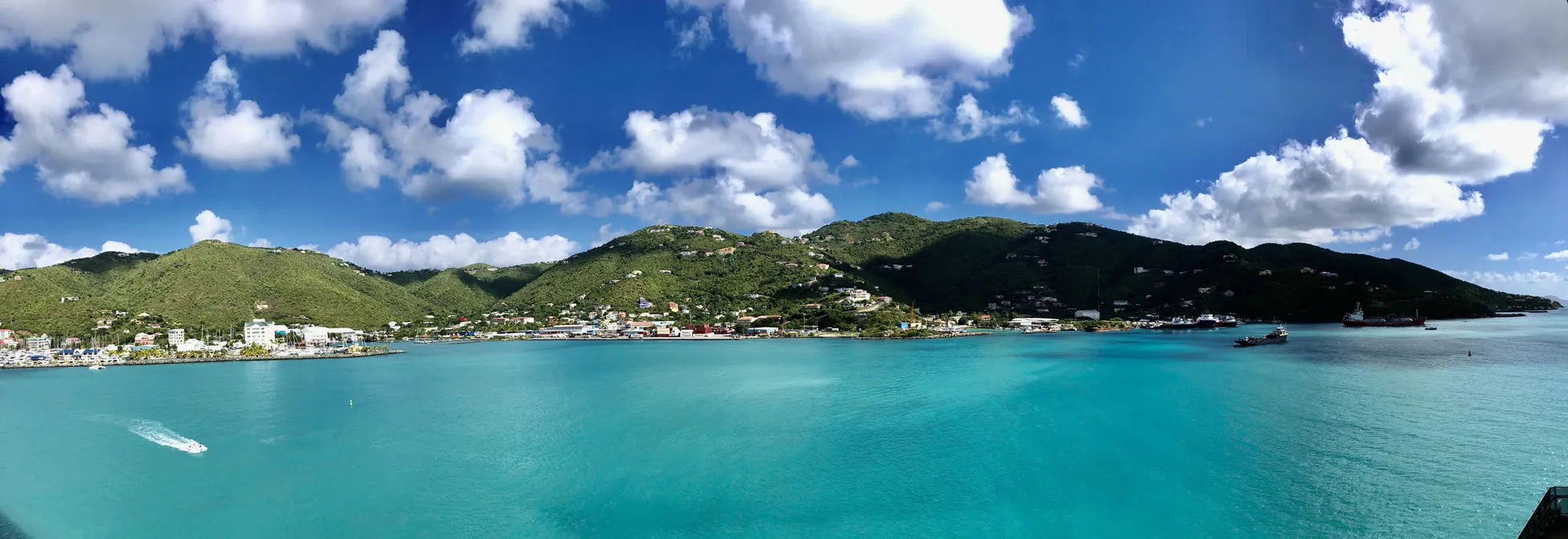 Turquoise Caribbean bay with green mountains and coastal town