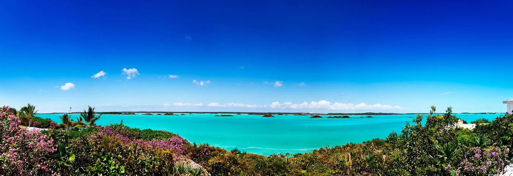 Turquoise waters and lush tropical vegetation with small islands in distance