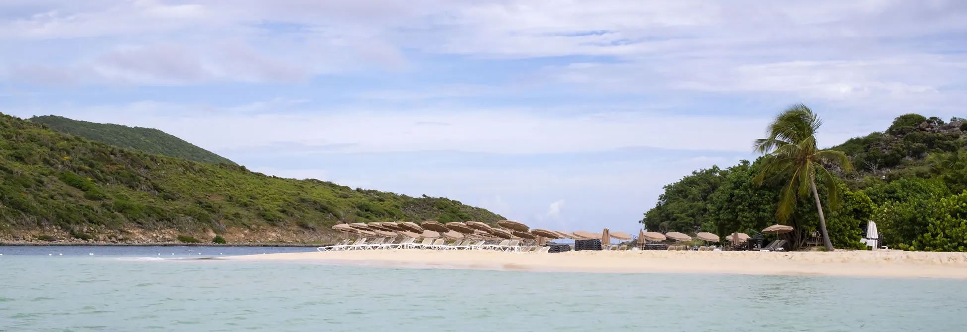 Tropical beach with palm trees, white sand, and beach umbrellas