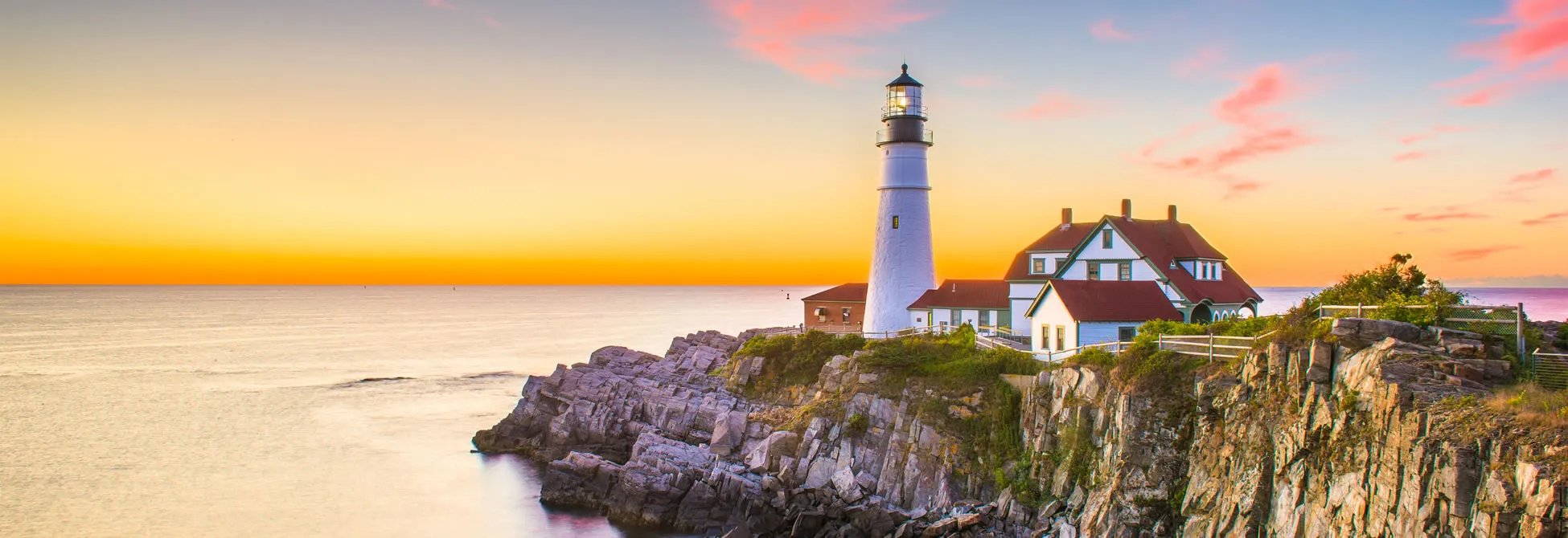 Portland Head Lighthouse at sunset on rocky Maine coastline