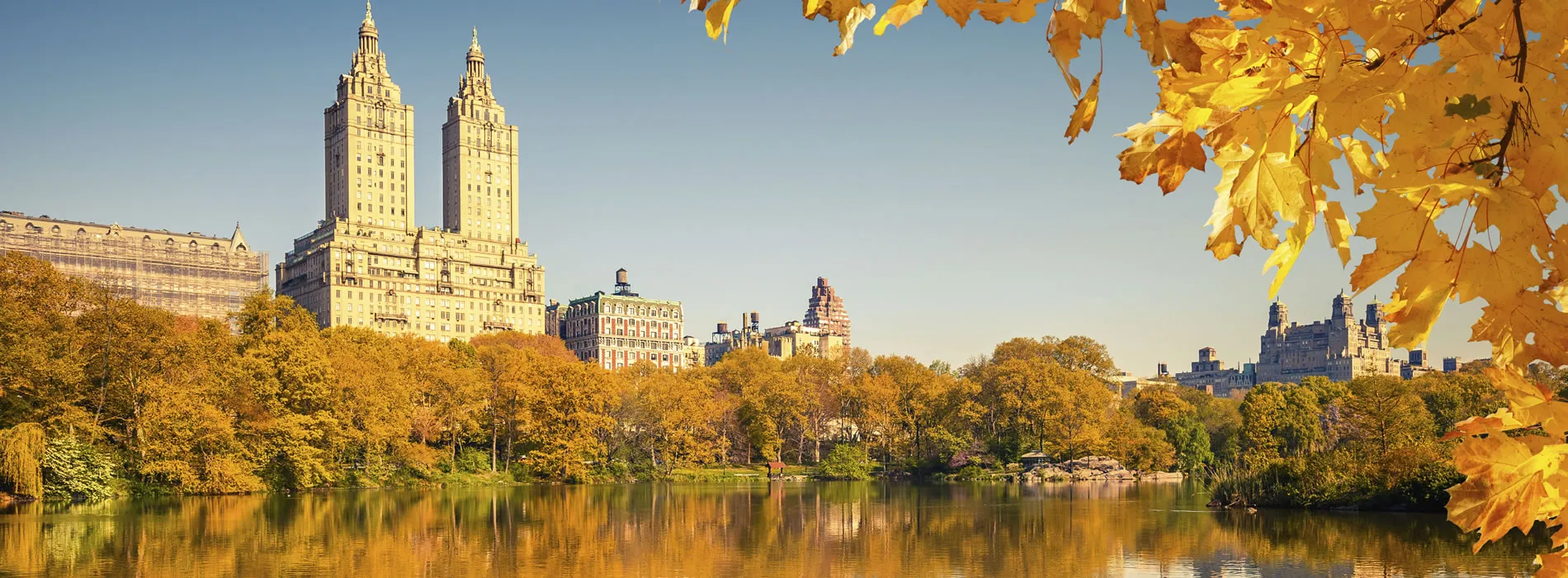 Autumn view of Central Park lake with New York City skyline reflecting