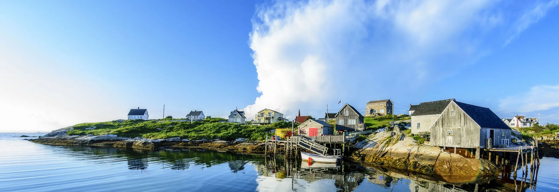 Peaceful coastal village with colorful houses on rocky shoreline and calm water
