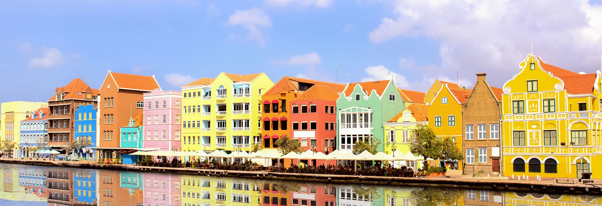 Colorful colonial buildings along waterfront in Curacao with reflection