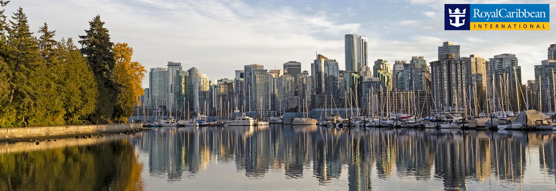 Vancouver skyline with marina, trees, and reflective water on calm morning