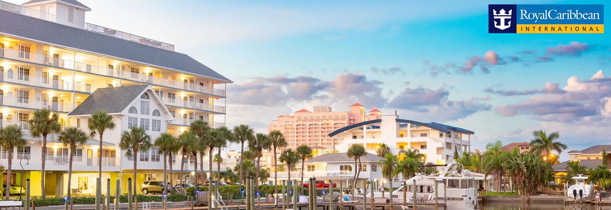 Royal Caribbean resort with boats and palm trees at sunset