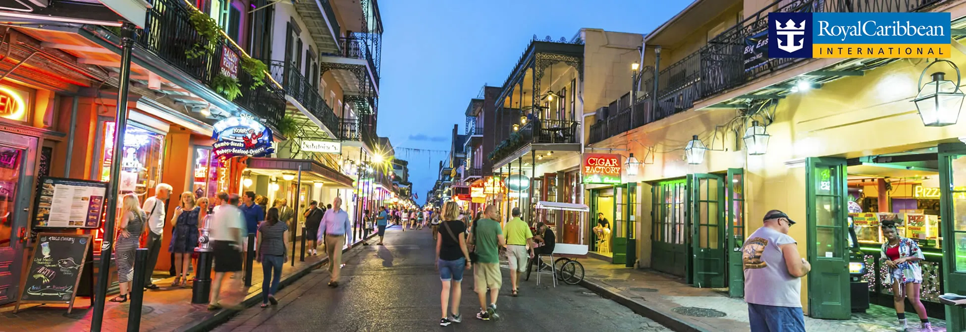 Bustling French Quarter street in New Orleans at twilight with shops and pedestrians