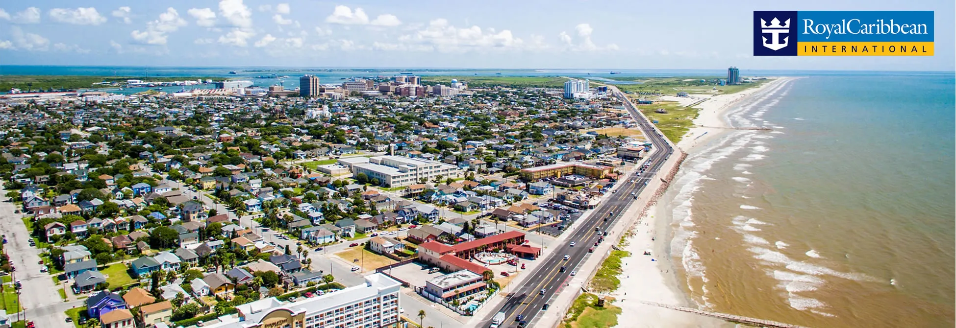 Aerial view of coastal city with beach, houses, and roadway