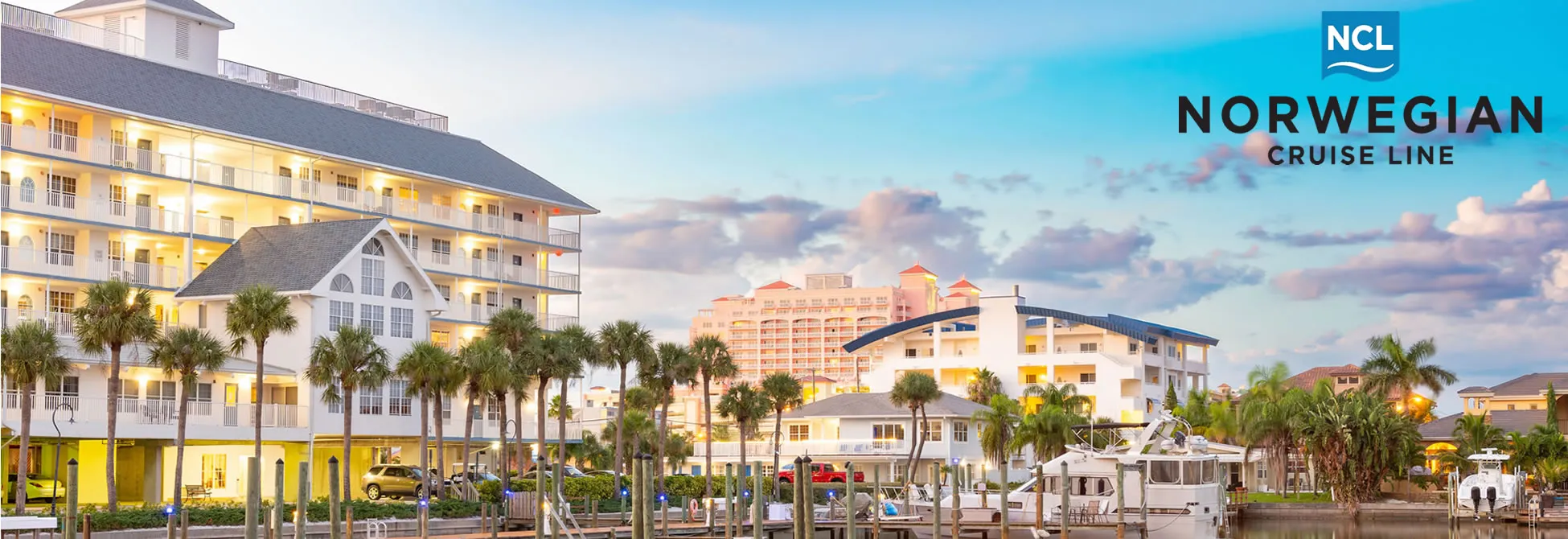 Norwegian Cruise Line resort with palm trees and boats at sunset