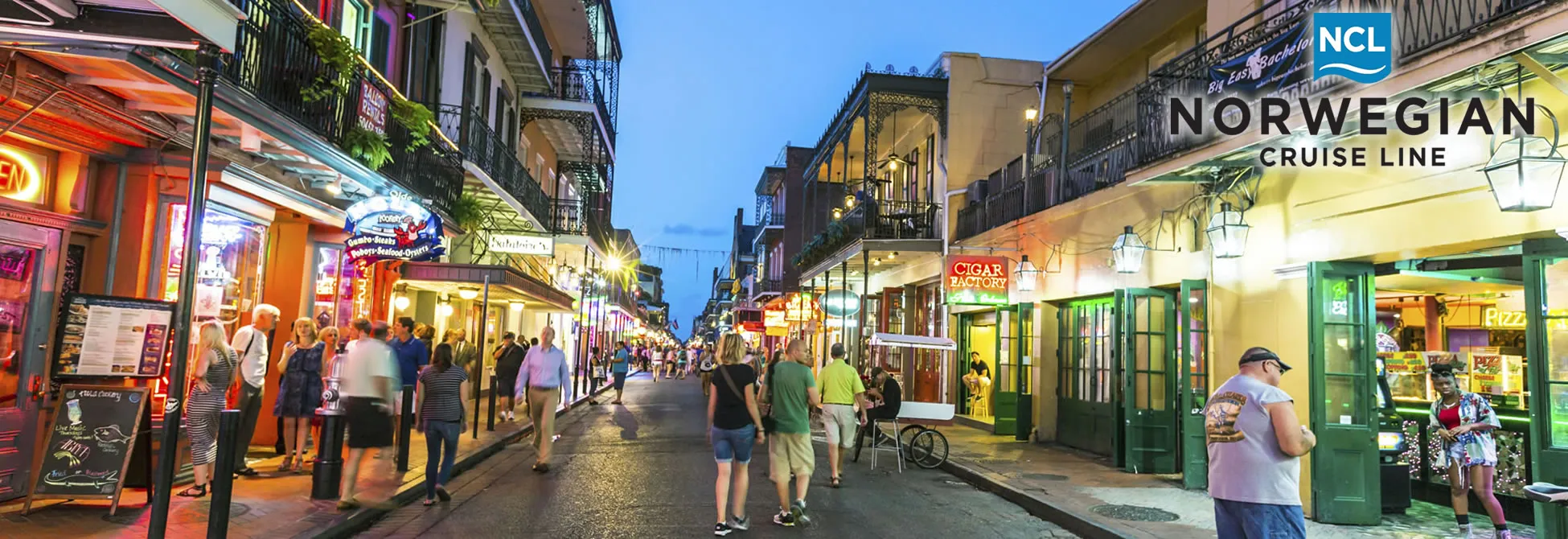 Bustling Bourbon Street in New Orleans at twilight with shops and pedestrians