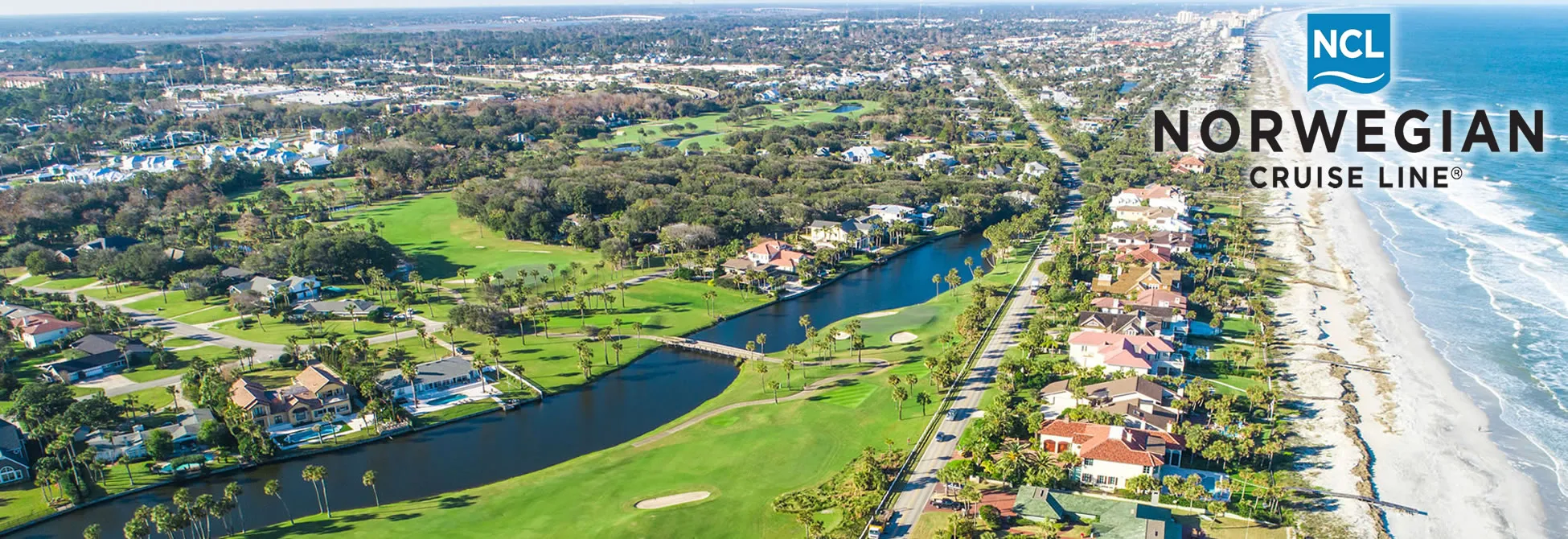 Aerial view of coastal golf course with canal, homes, and Norwegian Cruise Line logo