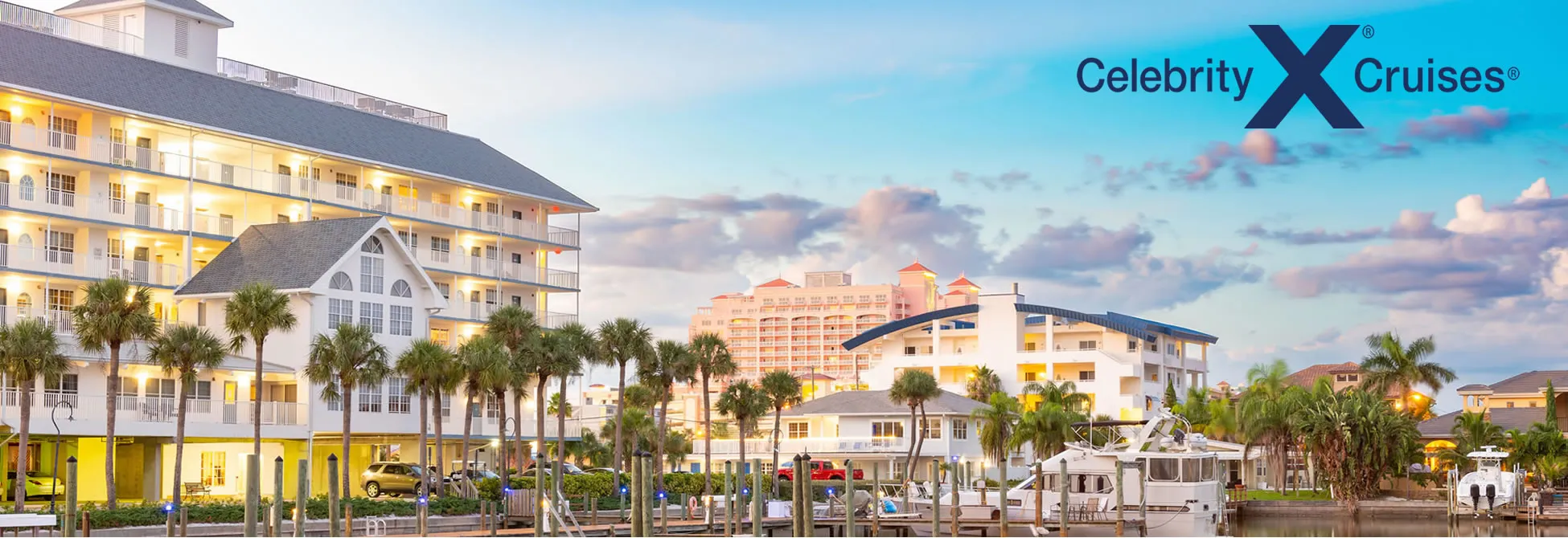 Celebrity Cruises resort with palm trees, boats, and waterfront buildings at sunset