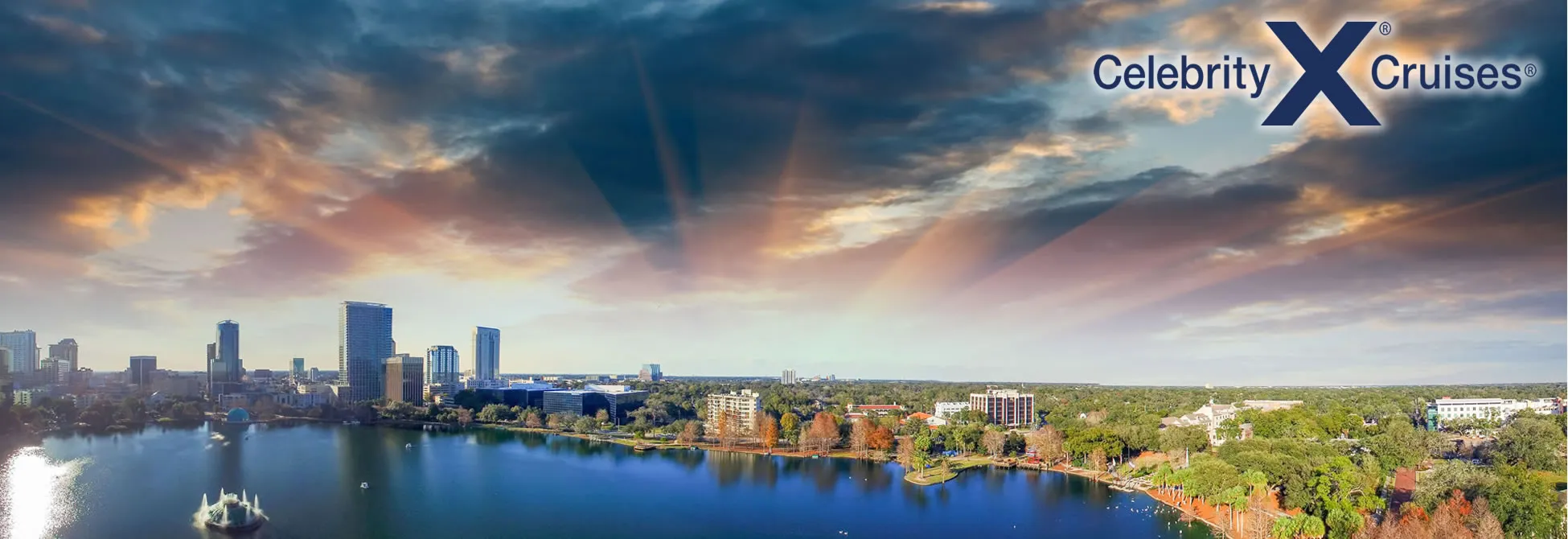 Orlando skyline with lake, trees, and dramatic sunset clouds