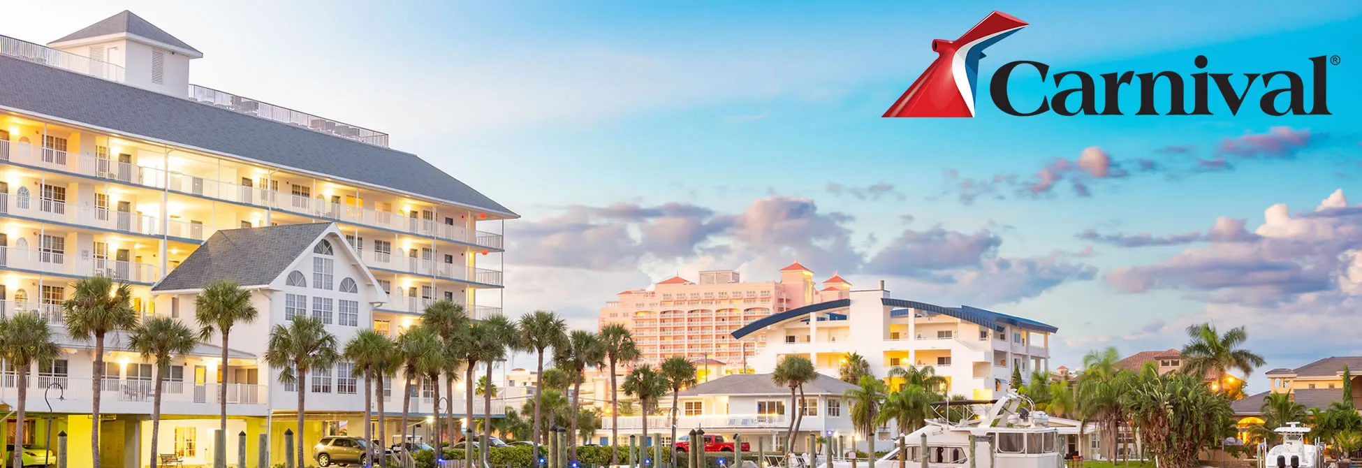Carnival cruise resort with palm trees and multicolored buildings at sunset