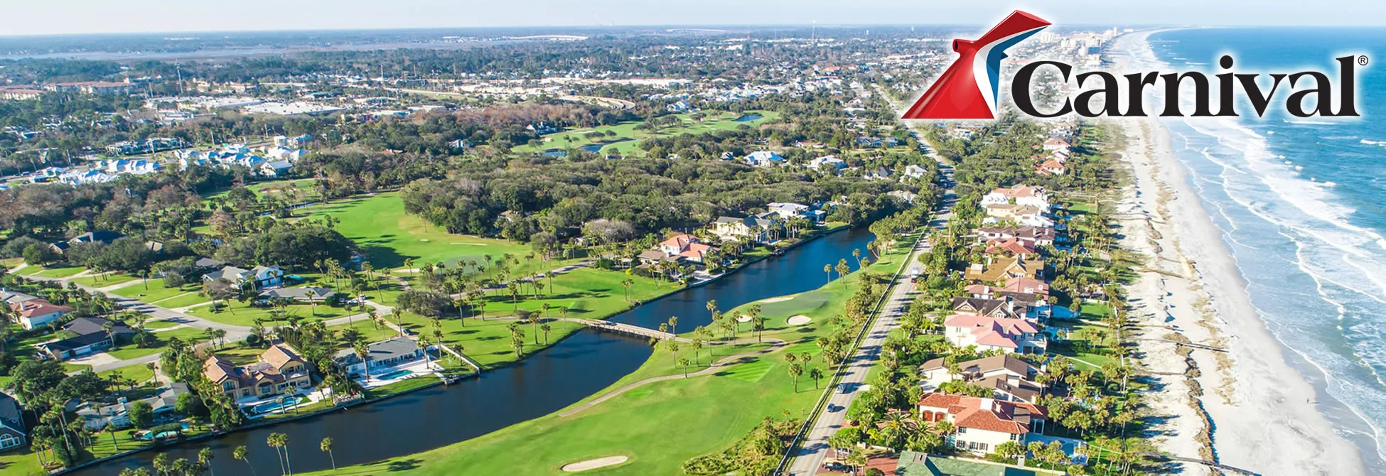Aerial view of coastal resort with golf course, waterway, and Carnival logo
