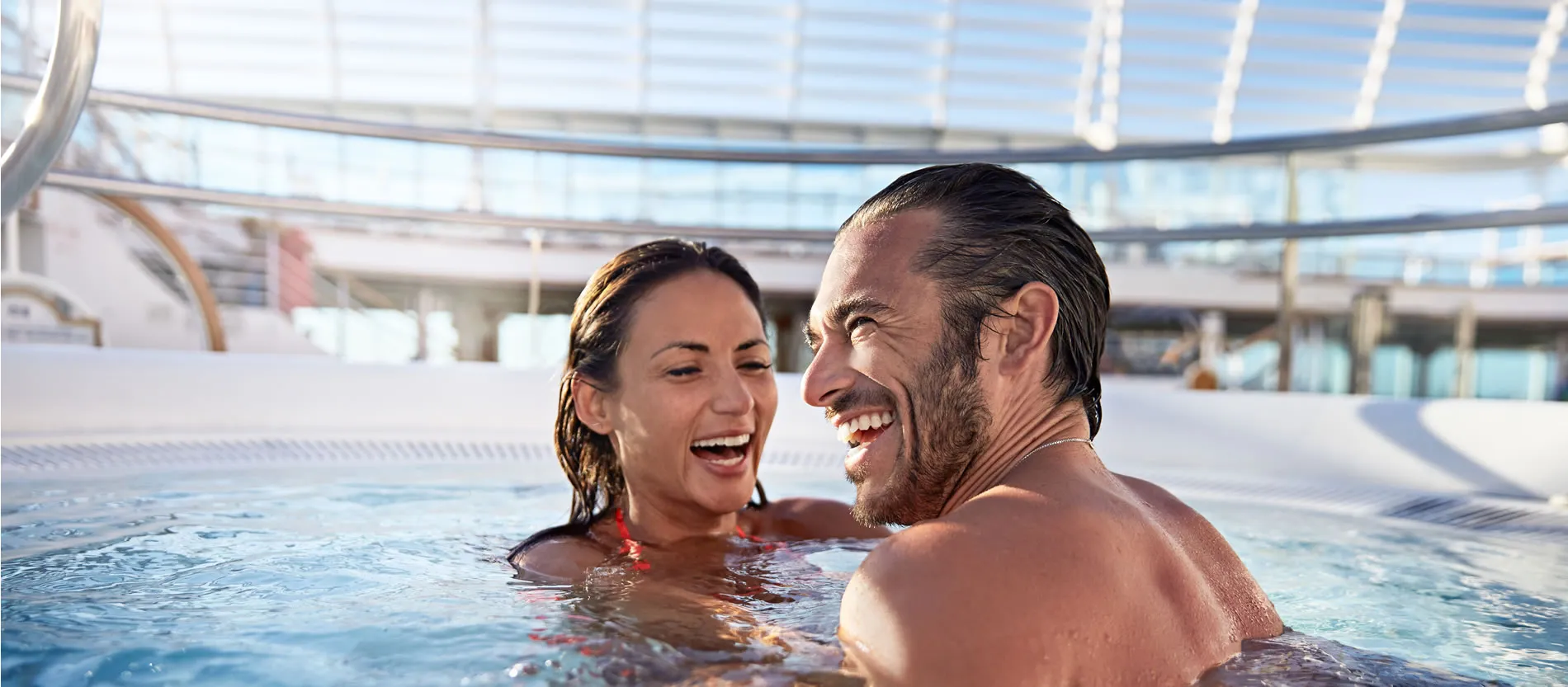 Couple laughing together in a swimming pool on a cruise ship