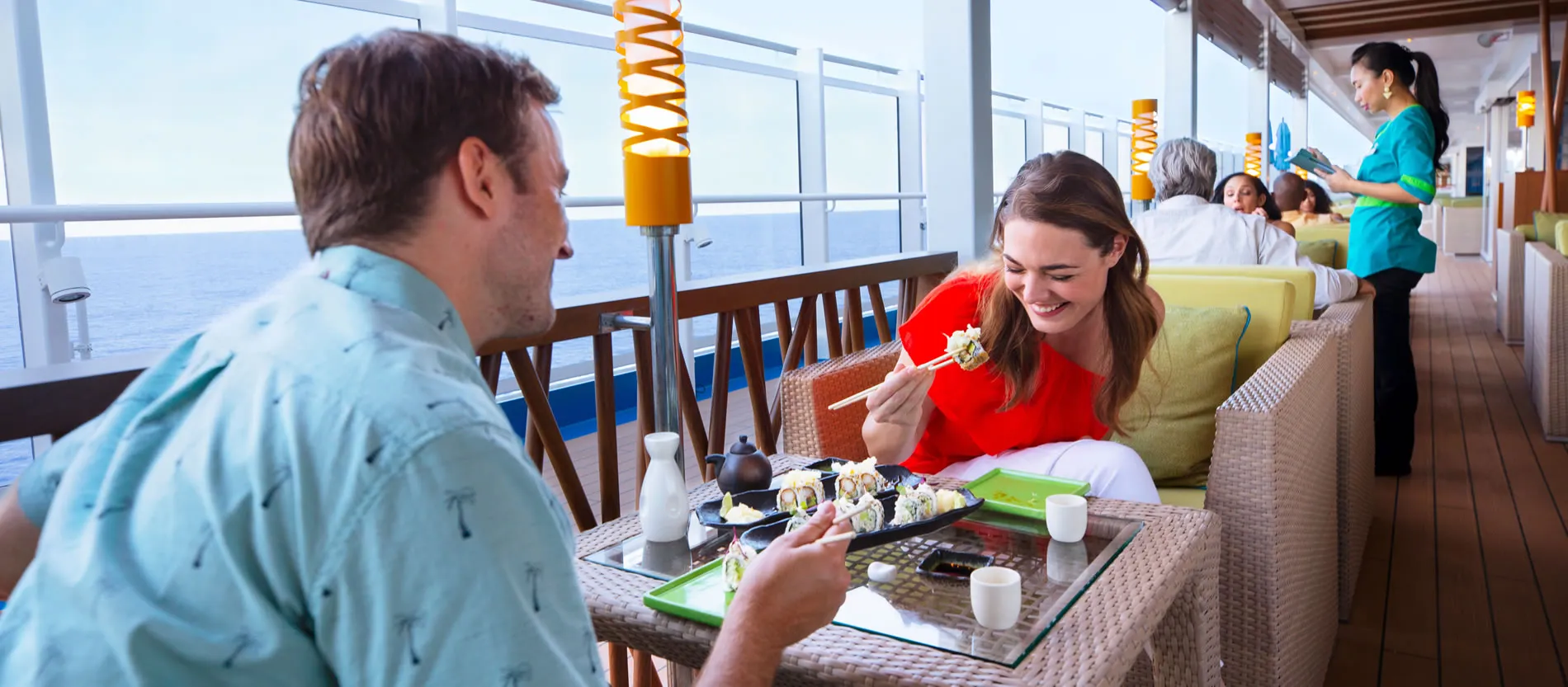 Couple enjoying sushi together on cruise ship deck with ocean view