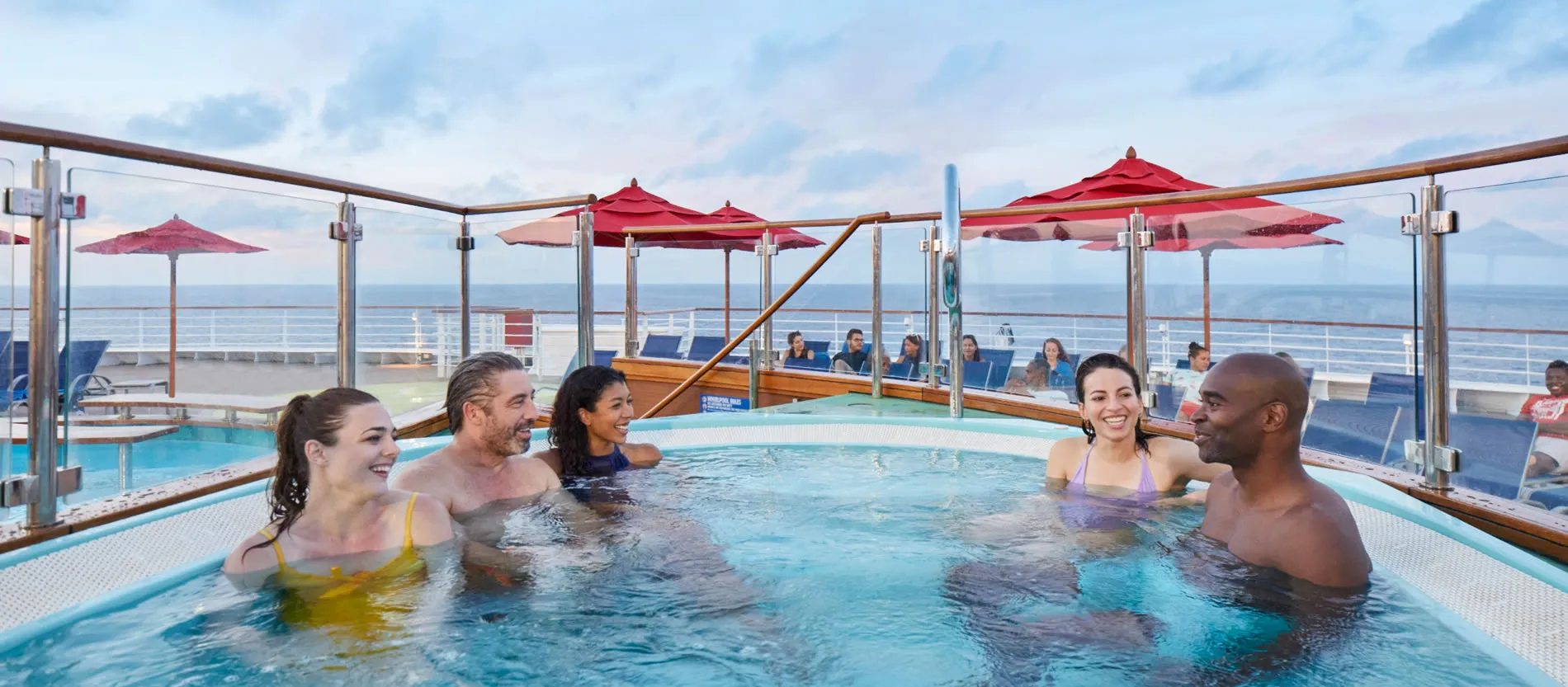 People relaxing in hot tub on cruise ship deck with ocean view