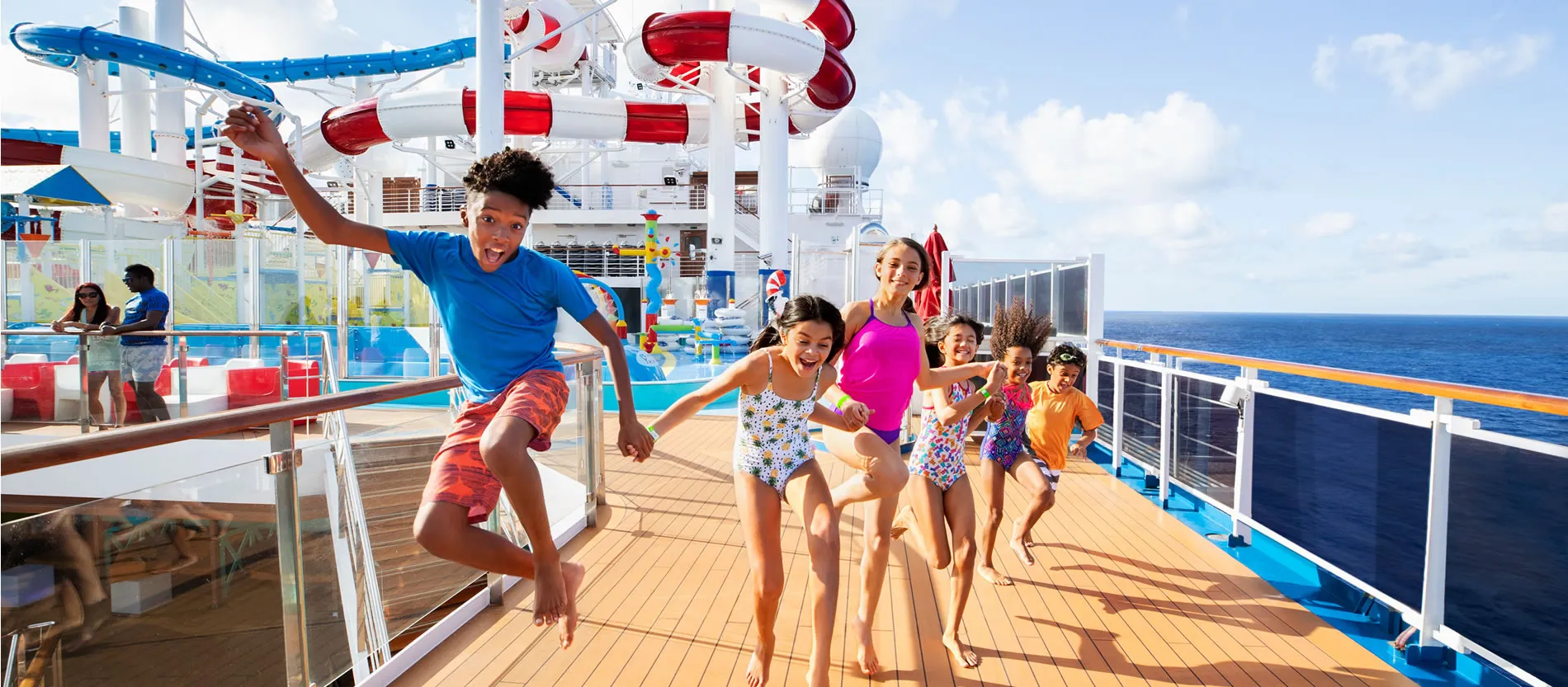 Kids excitedly running on cruise ship deck with colorful water slides