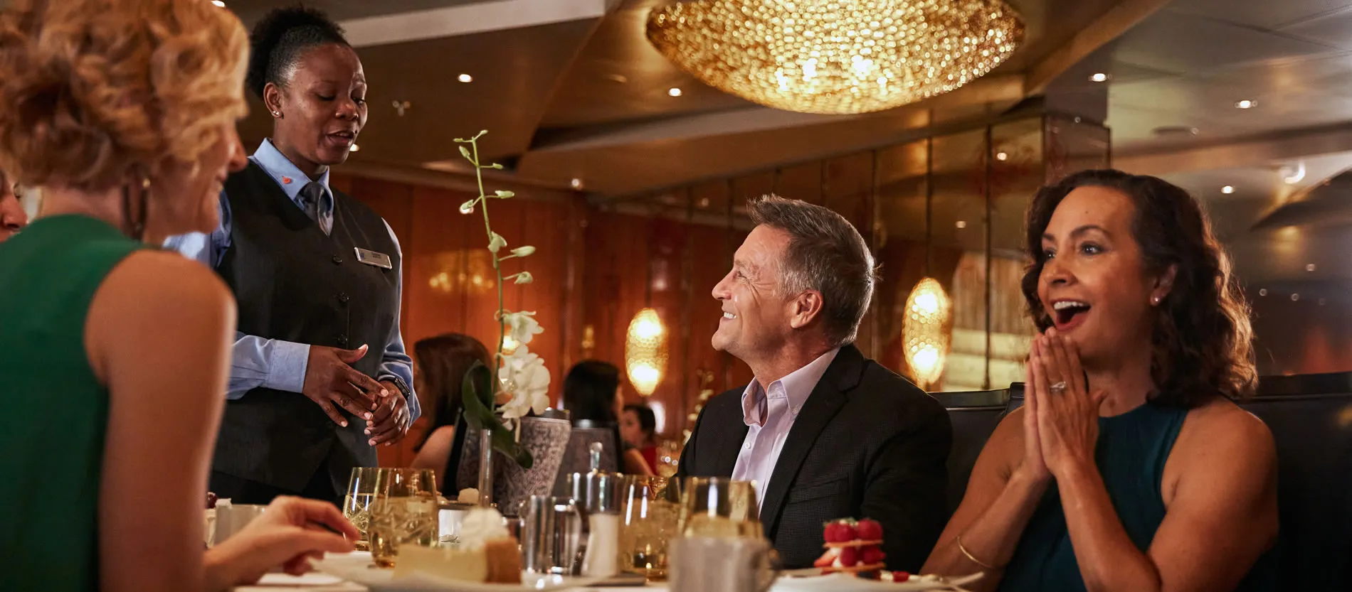 Elegant restaurant scene with guests and server laughing together
