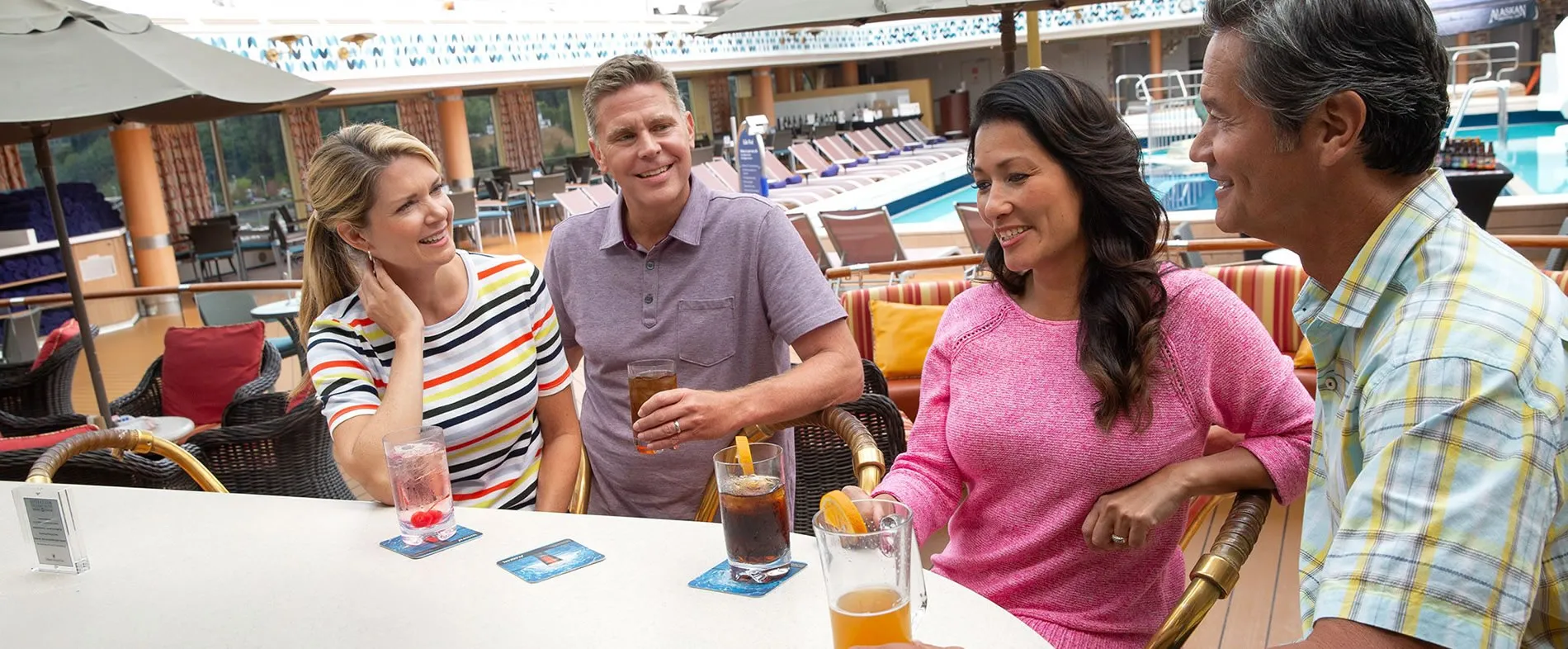 Friends enjoying drinks together on a cruise ship deck
