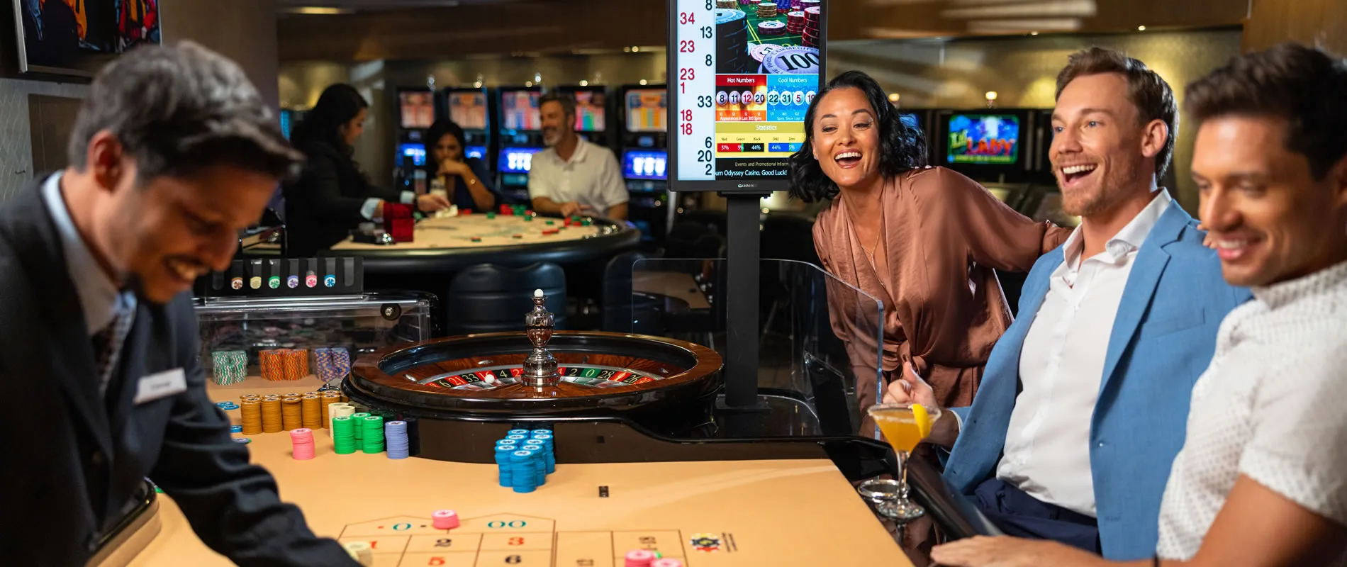 Casino roulette table with players and colorful chips laughing together