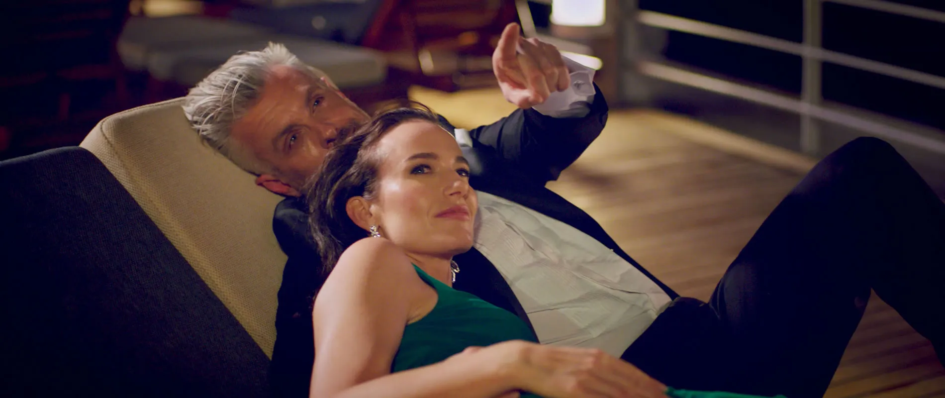 Two people relaxing together on a chair, dressed elegantly