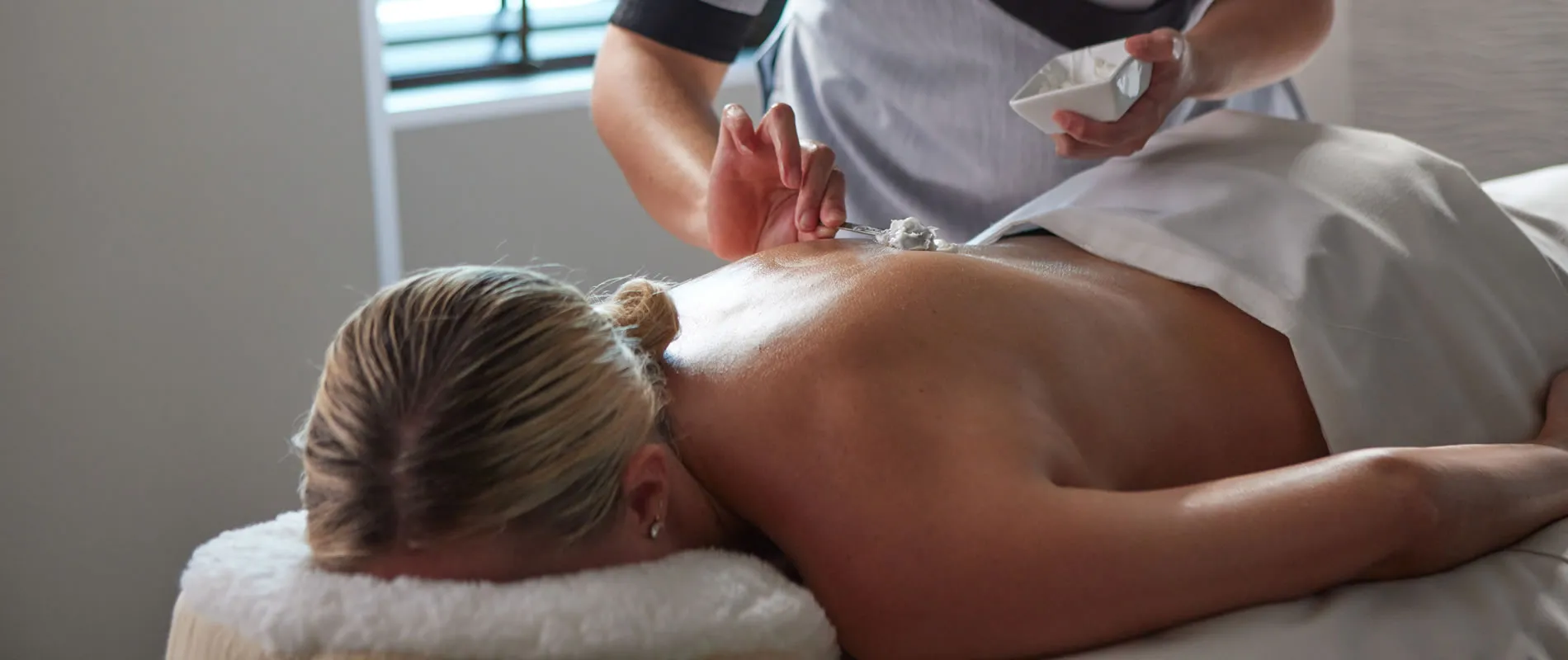 Spa treatment with therapist applying cream during relaxing massage