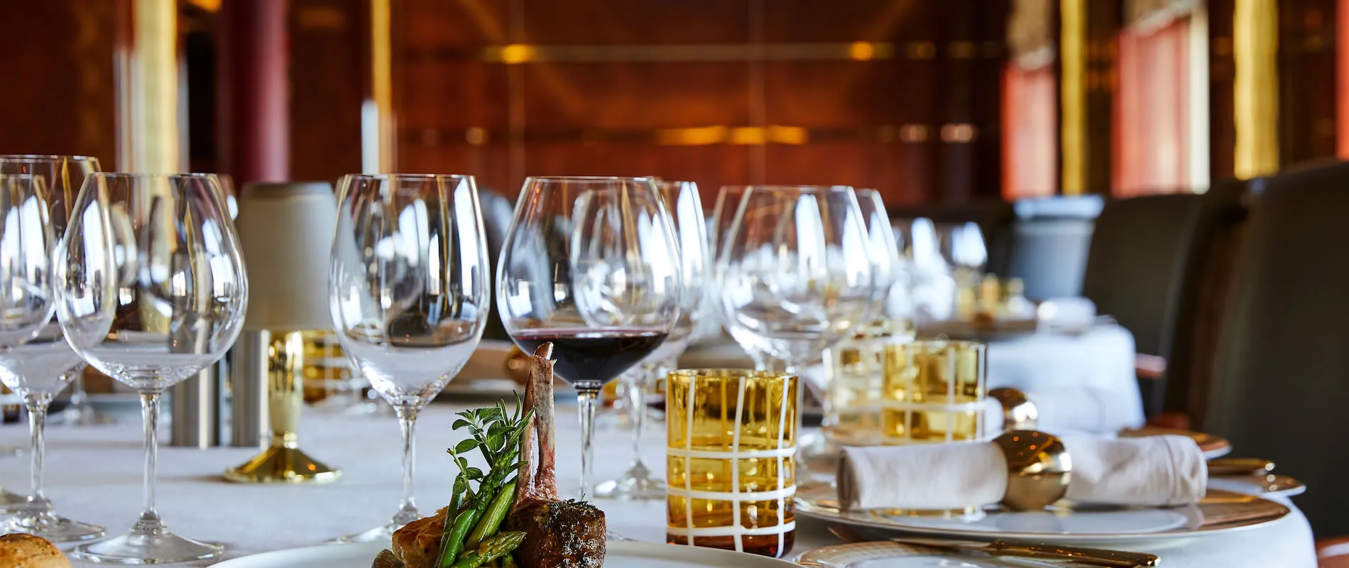 Elegant dining table set with wine glasses, plates, and gourmet meal
