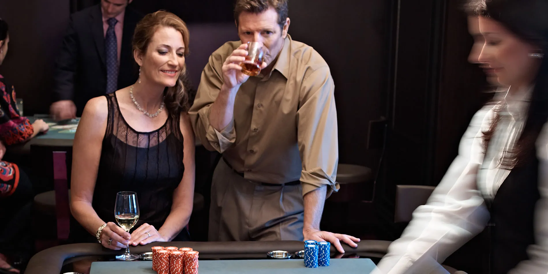 Casino scene with poker chips, elegantly dressed people drinking wine