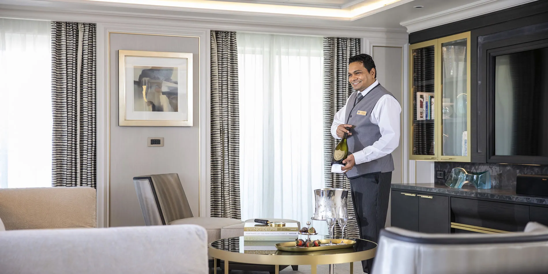 Hotel staff prepares champagne service in elegant room with artwork