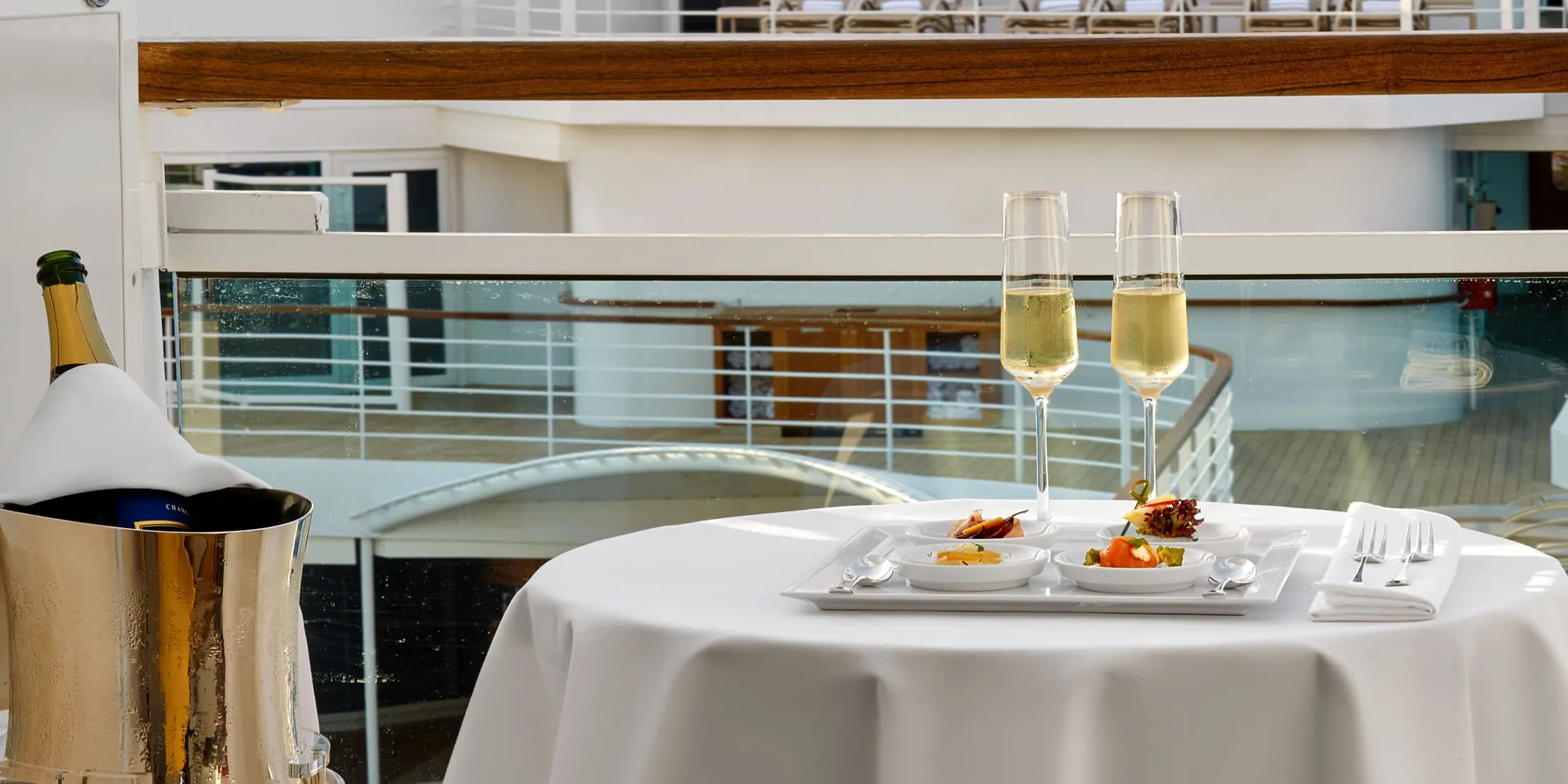 Elegant dining setup with champagne, gourmet plates, and white tablecloth