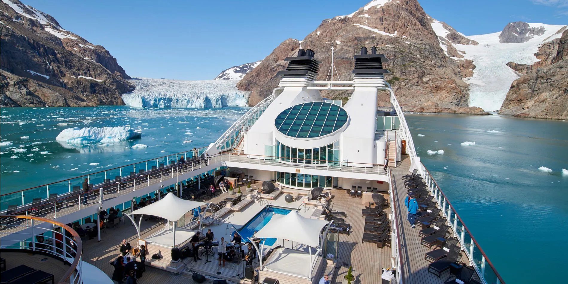 Cruise ship deck with glacier and snow-capped mountains in background