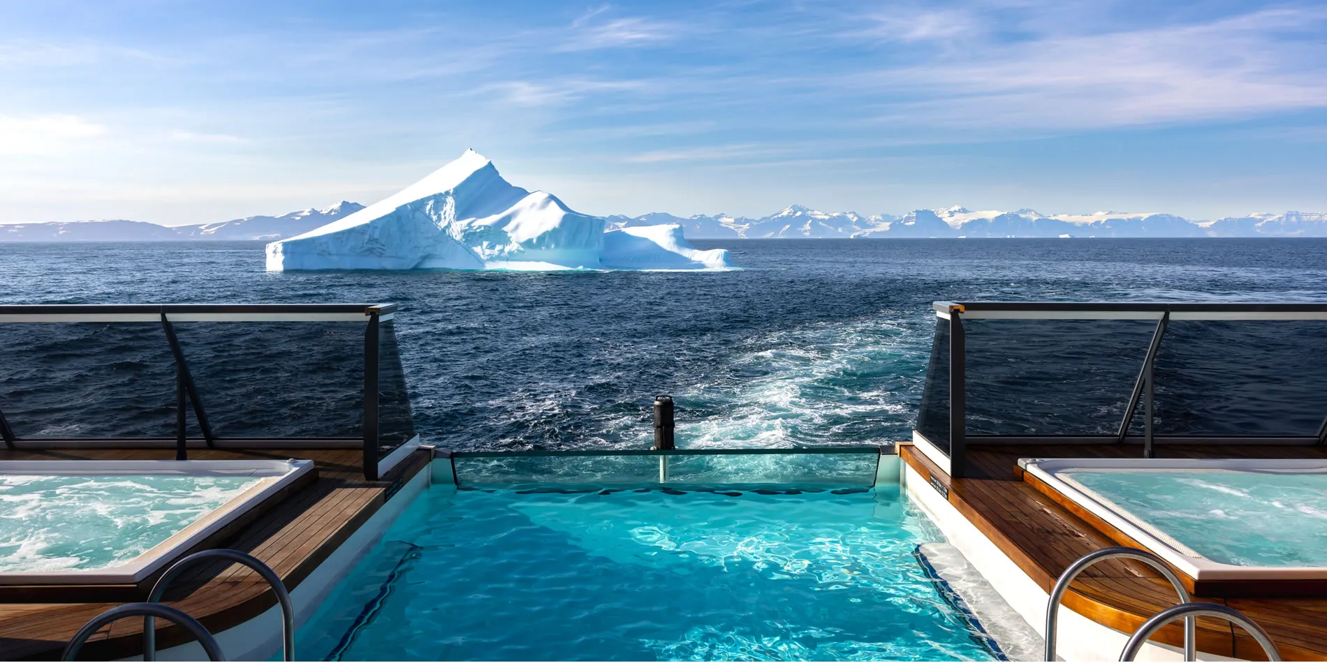 Cruise ship pool with majestic iceberg and snowy mountains in background