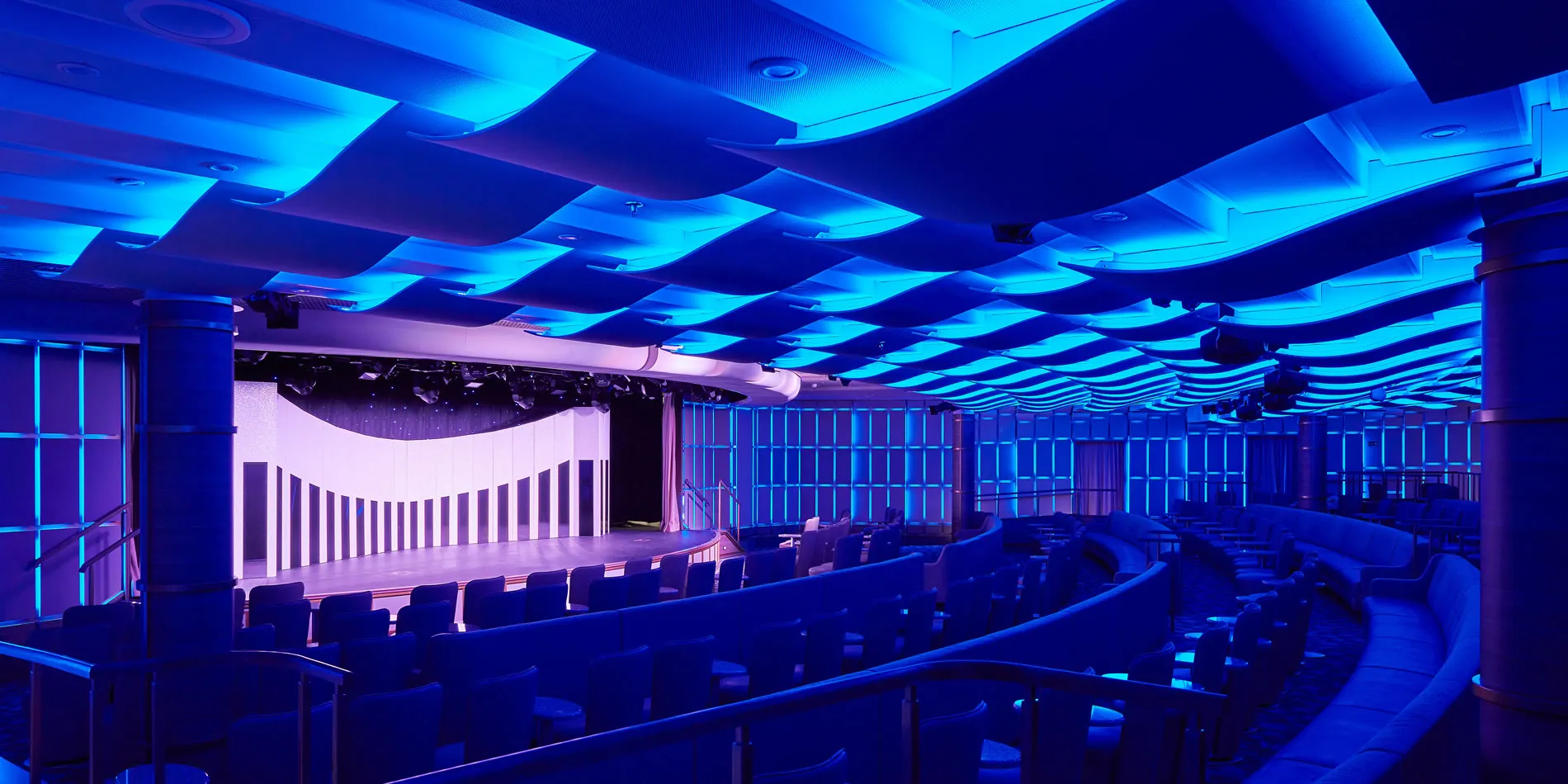 Empty theater with curved seating and dramatic blue lighting on ceiling