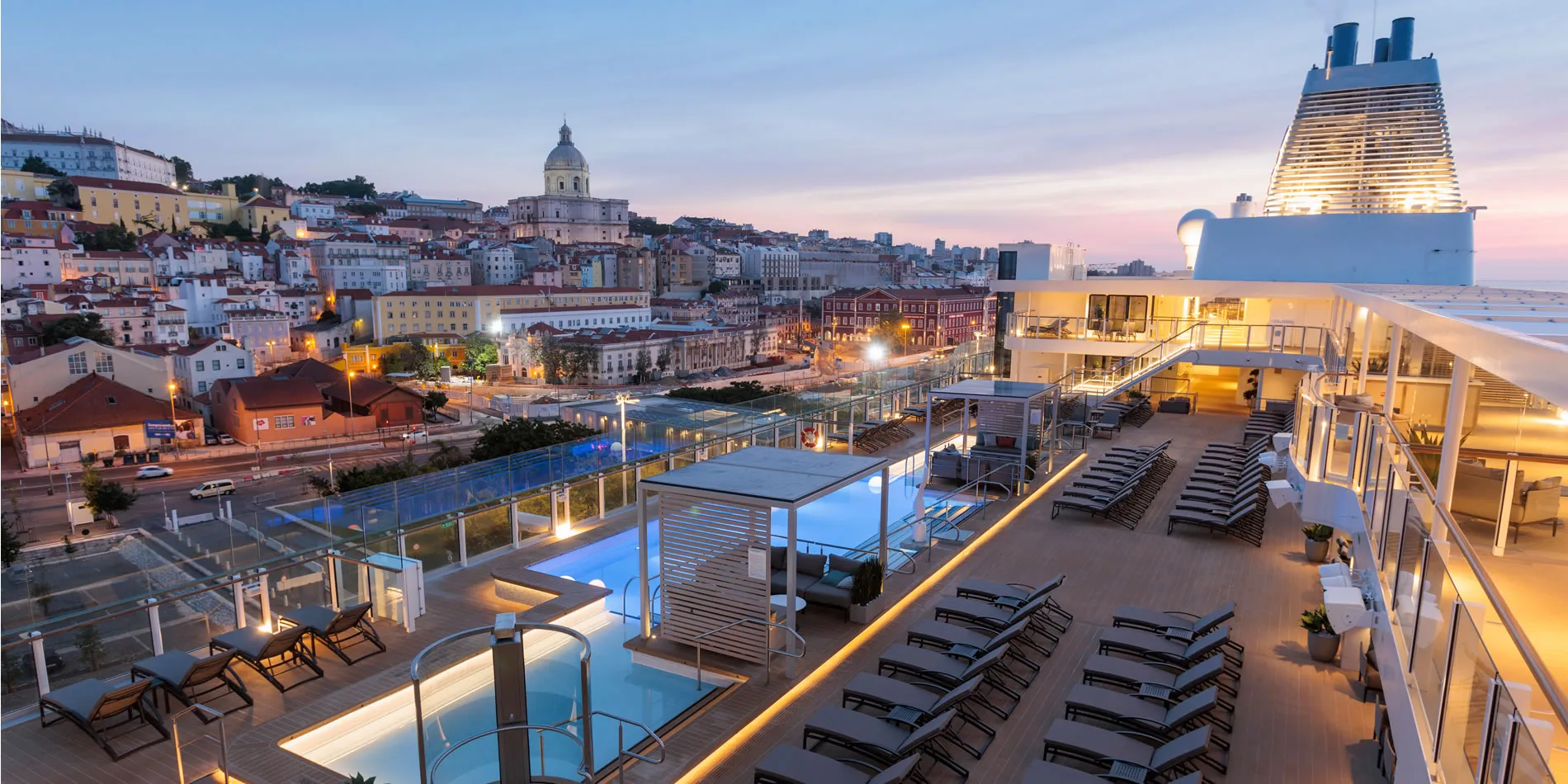 Cruise ship deck overlooking historic Lisbon cityscape at twilight