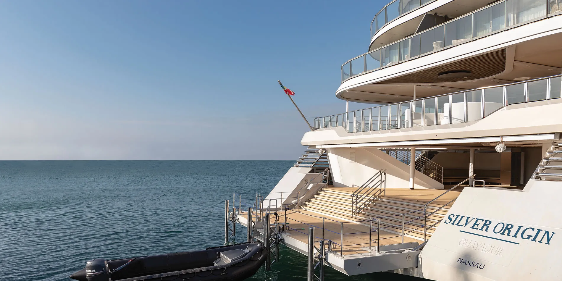 Luxury cruise ship Silver Origin docked on calm blue ocean waters
