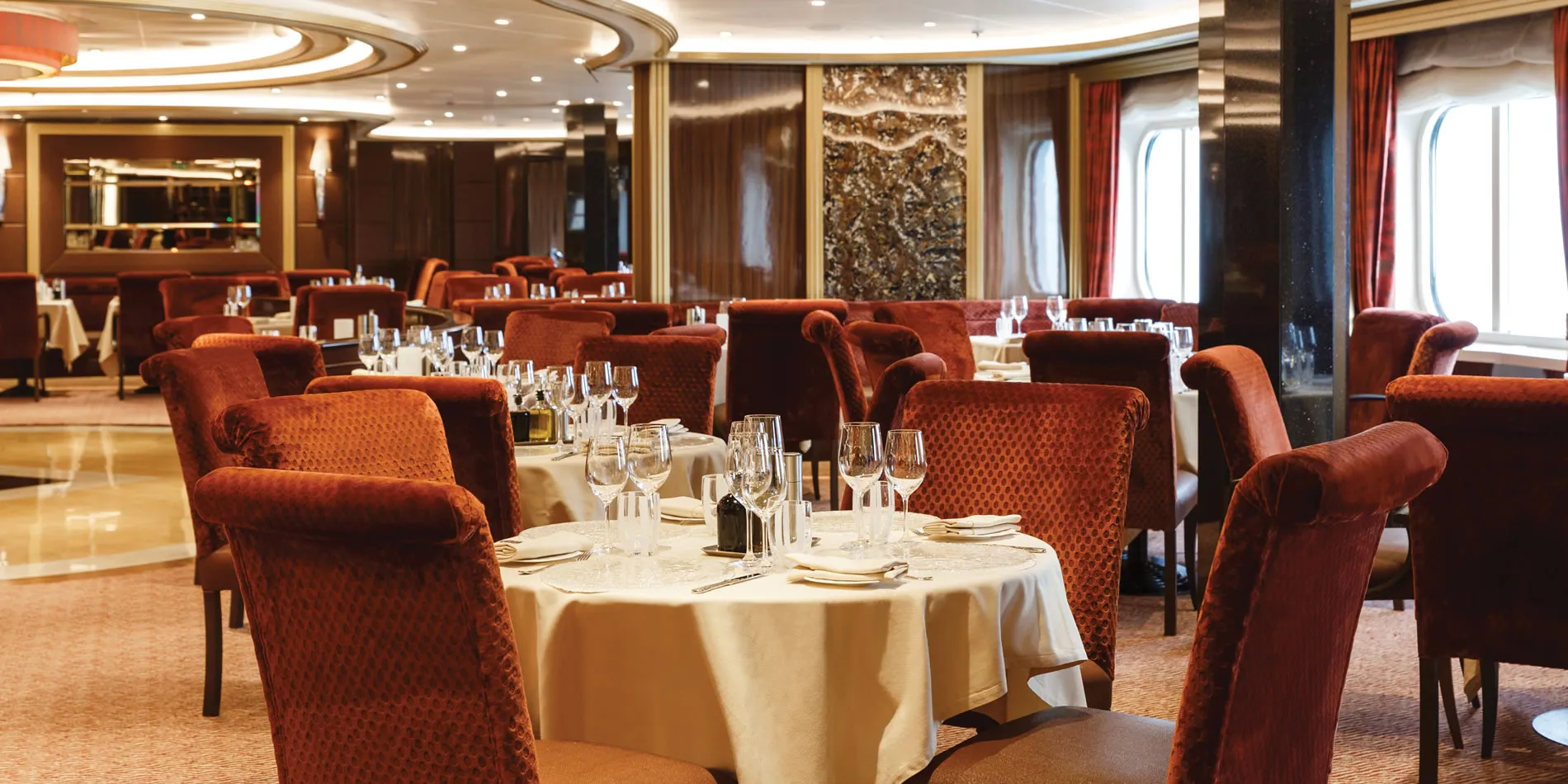 Elegant cruise ship dining room with red velvet chairs and white tablecloths