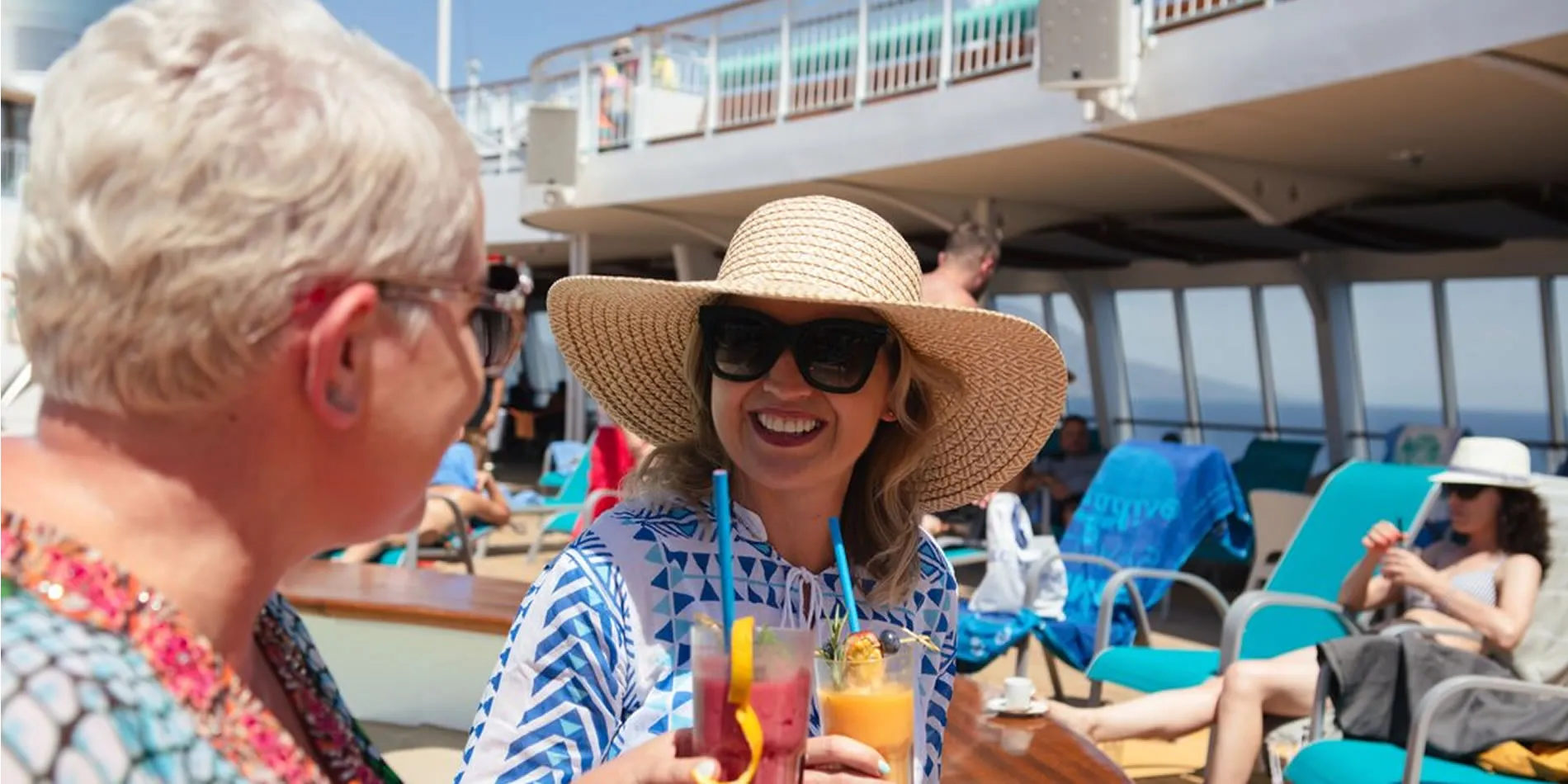 Woman in sun hat enjoying colorful drinks on cruise ship deck