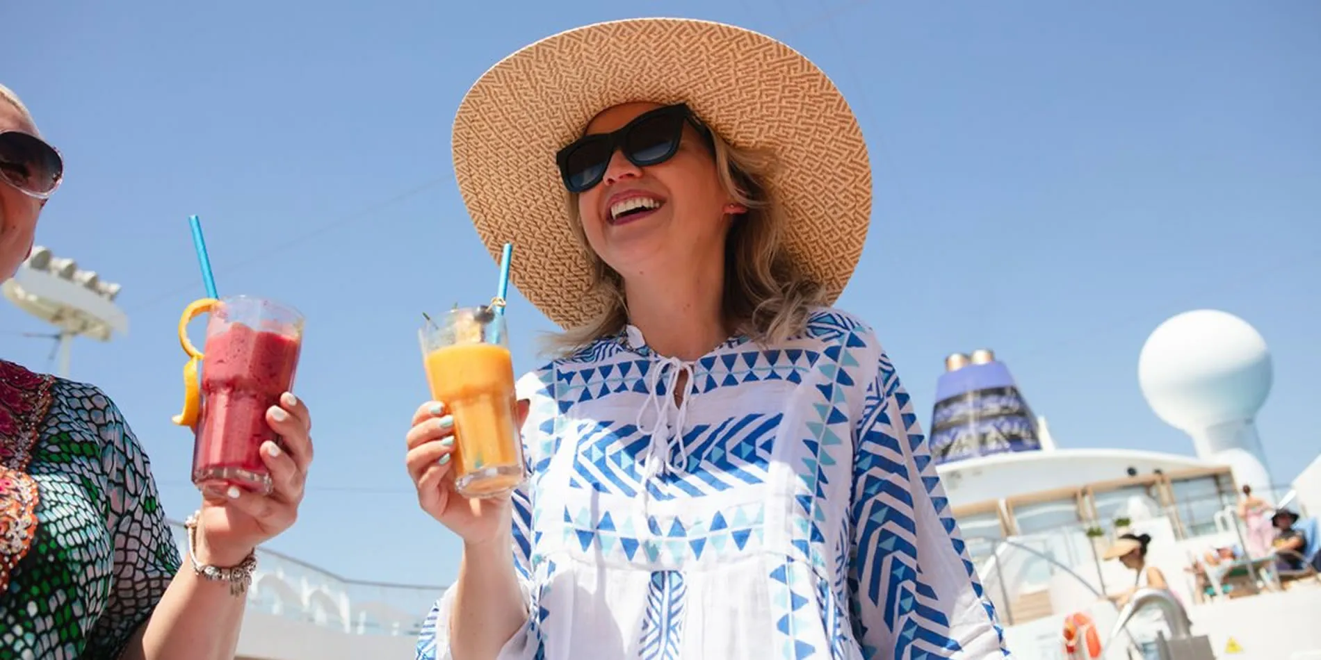 Woman in sun hat enjoying tropical drinks on cruise ship deck