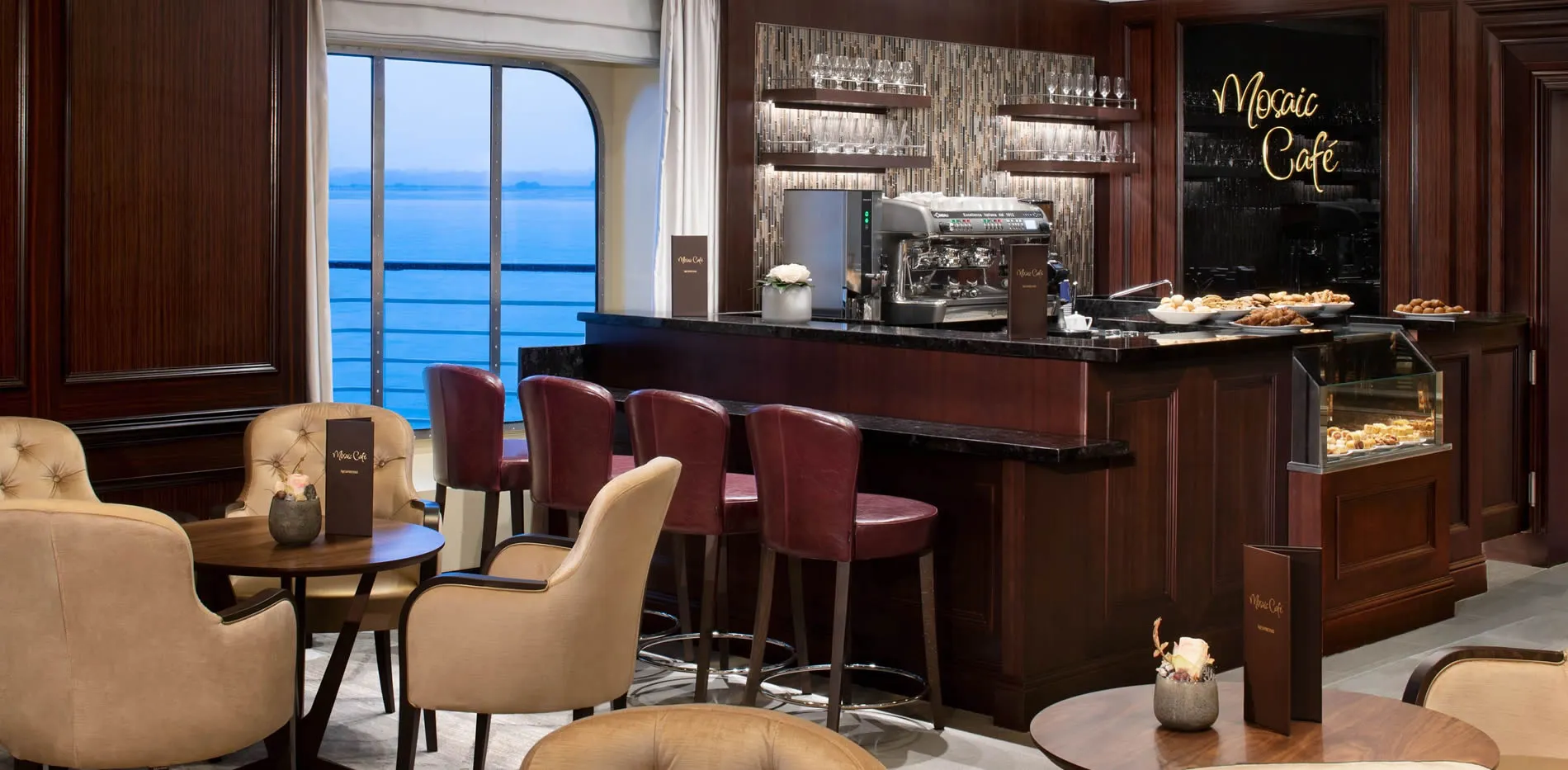 Elegant Mosaic Café with ocean view, coffee machine, and pastry display