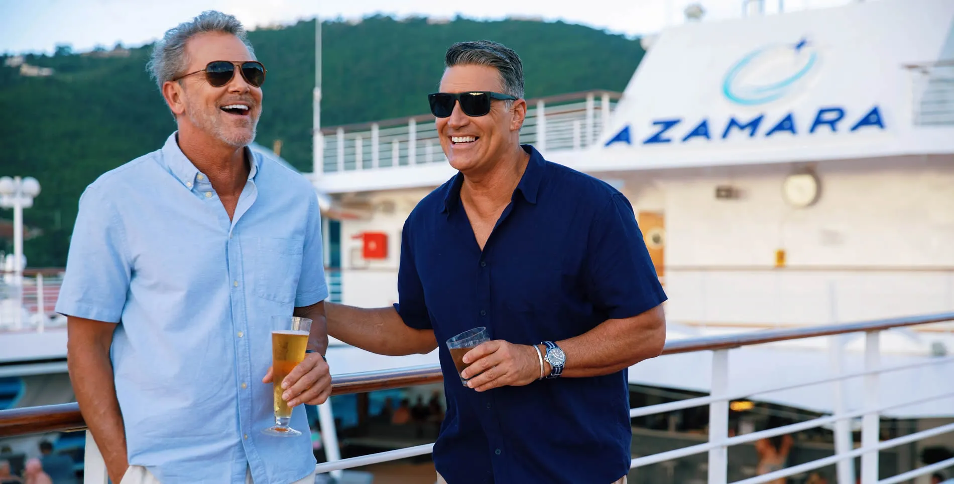 Two men enjoying drinks on an Azamara cruise ship deck