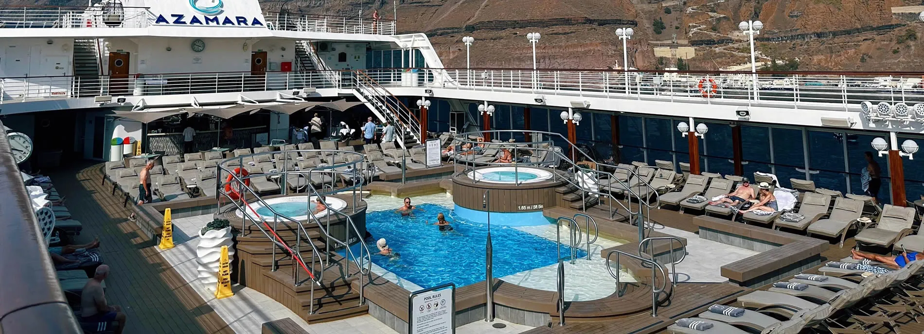 Azamara cruise ship deck with swimming pool, hot tub, and lounge chairs