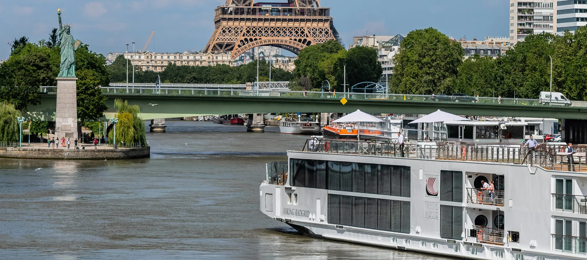 Eiffel Tower and Statue of Liberty replica with river cruise boat in Paris