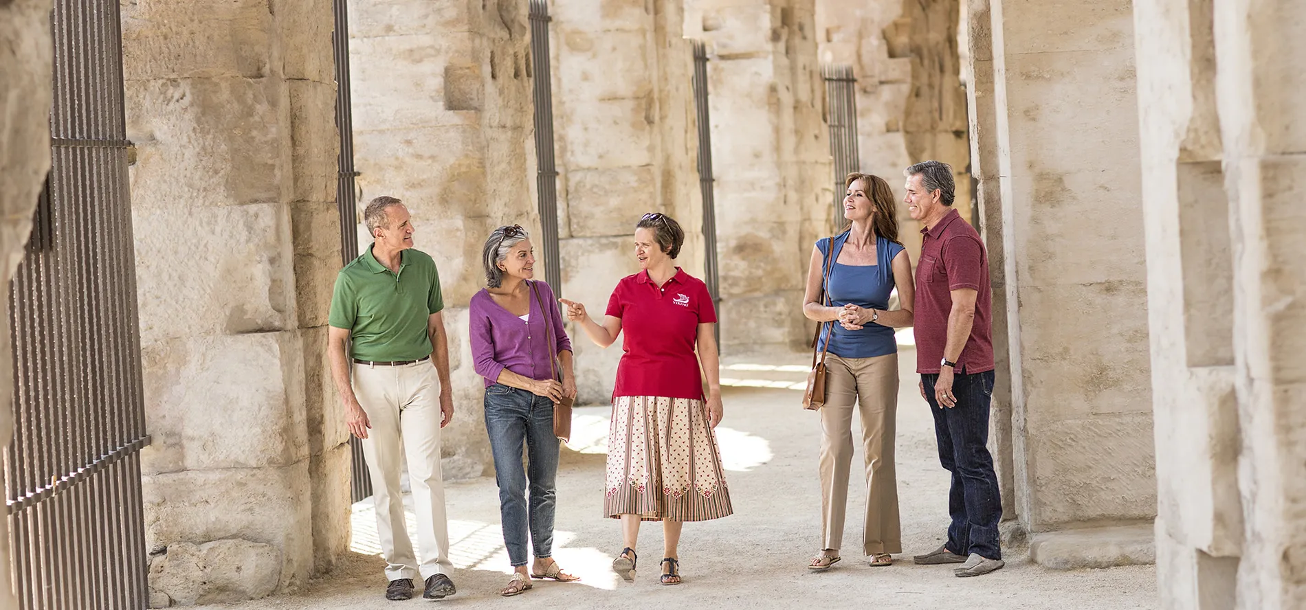 Group of tourists exploring ancient stone building with friendly conversation