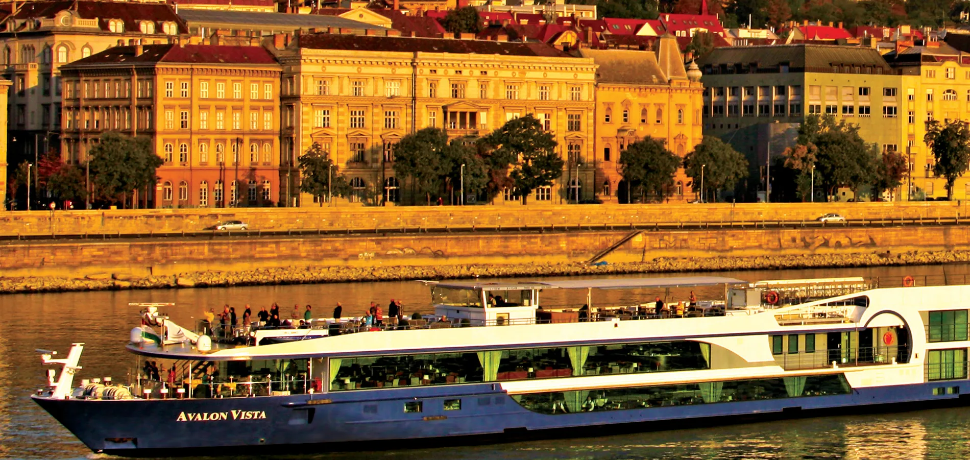 Avalon Vista cruise ship on river with historic European city buildings