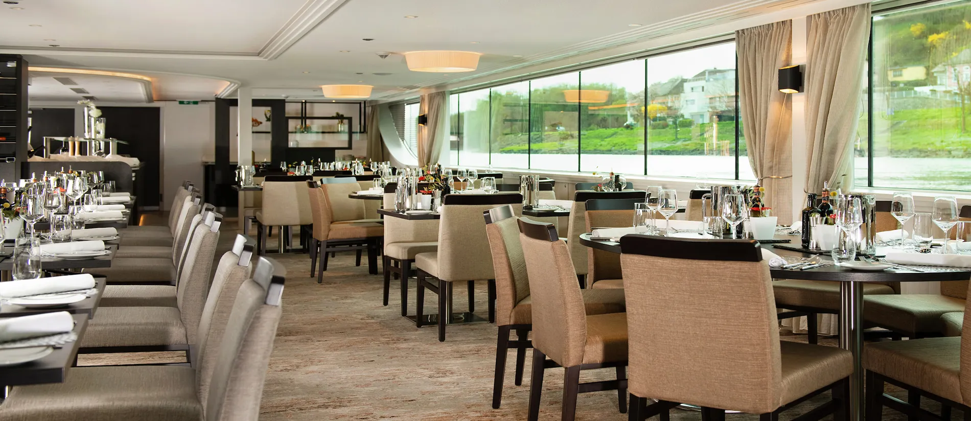 Elegant restaurant interior with tables, chairs, and large glass windows