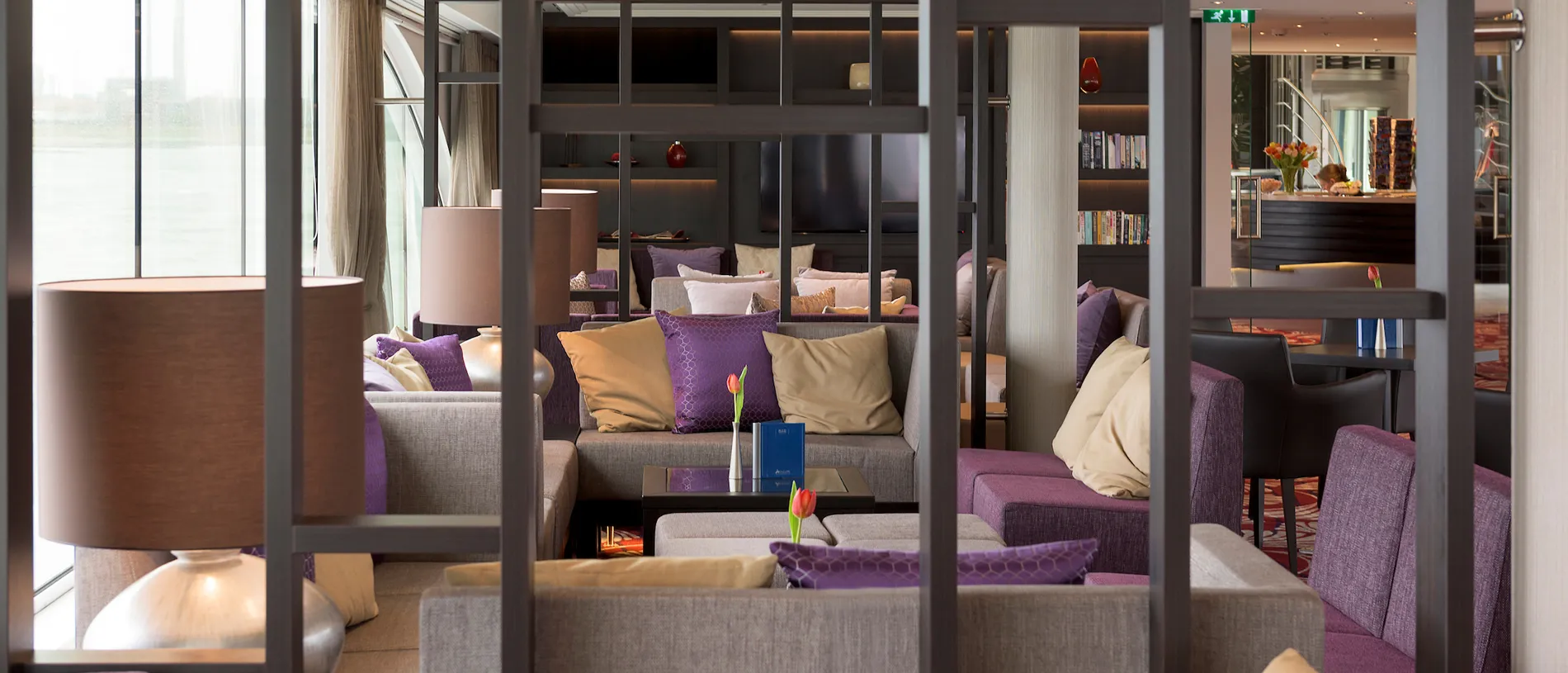 Cozy hotel lounge with purple and beige seating, divided by glass partitions