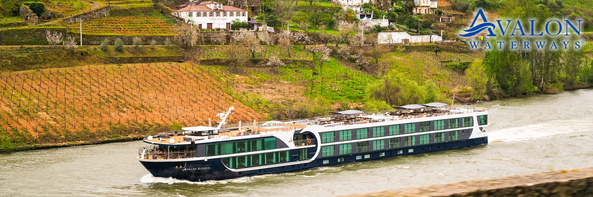 Avalon Waterways cruise ship sailing past vineyards along a scenic river